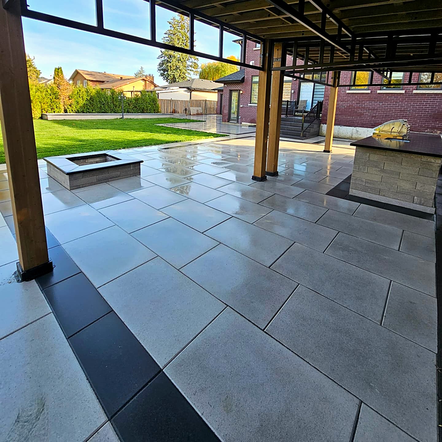 Covered patio with pergola and large-format grey pavers